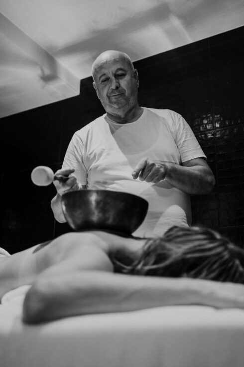 Masseur mit Klangschale am Rücken